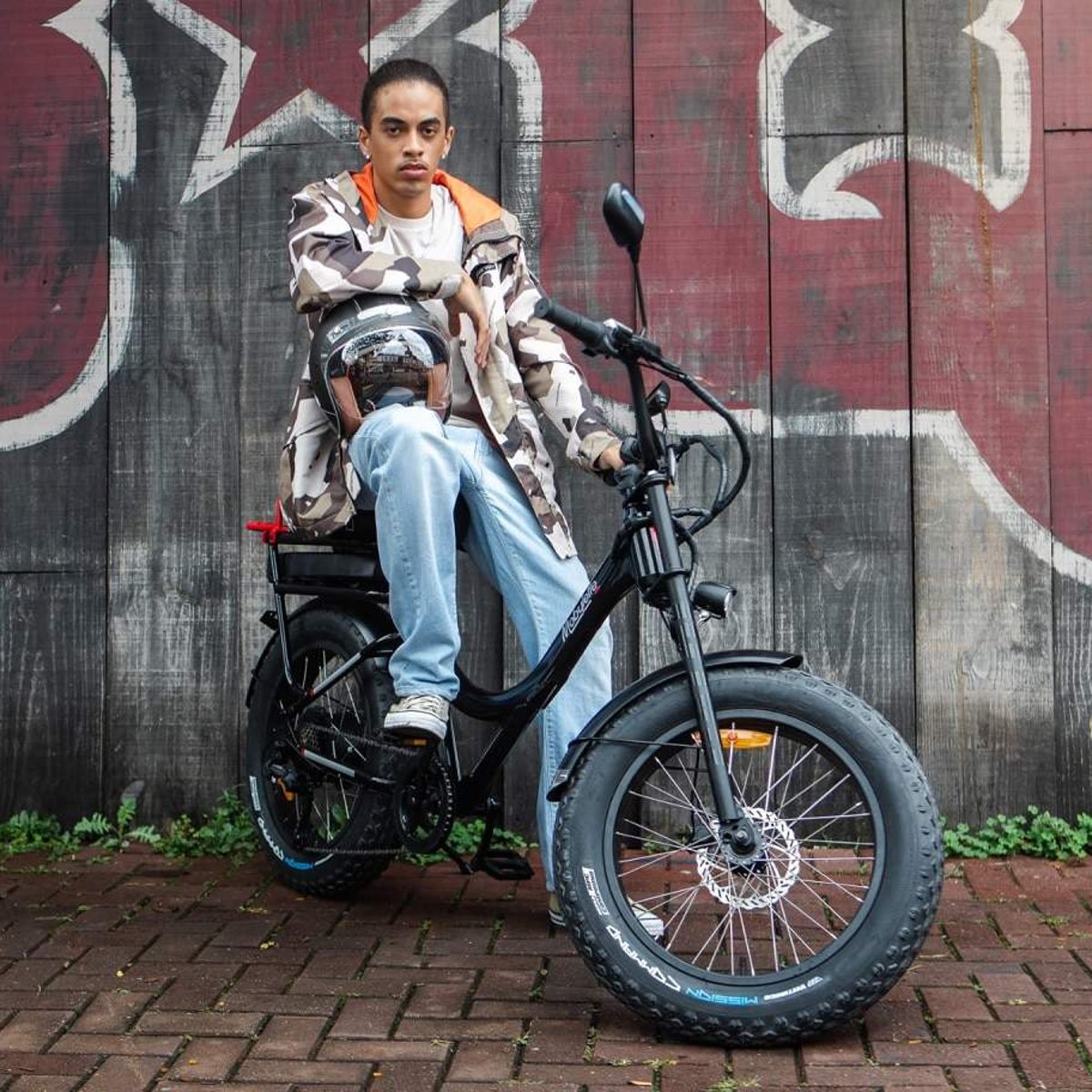 motos elétricas que não precisam de habilitação Jovem sentado em uma bicicleta elétrica Caloi Mobylette