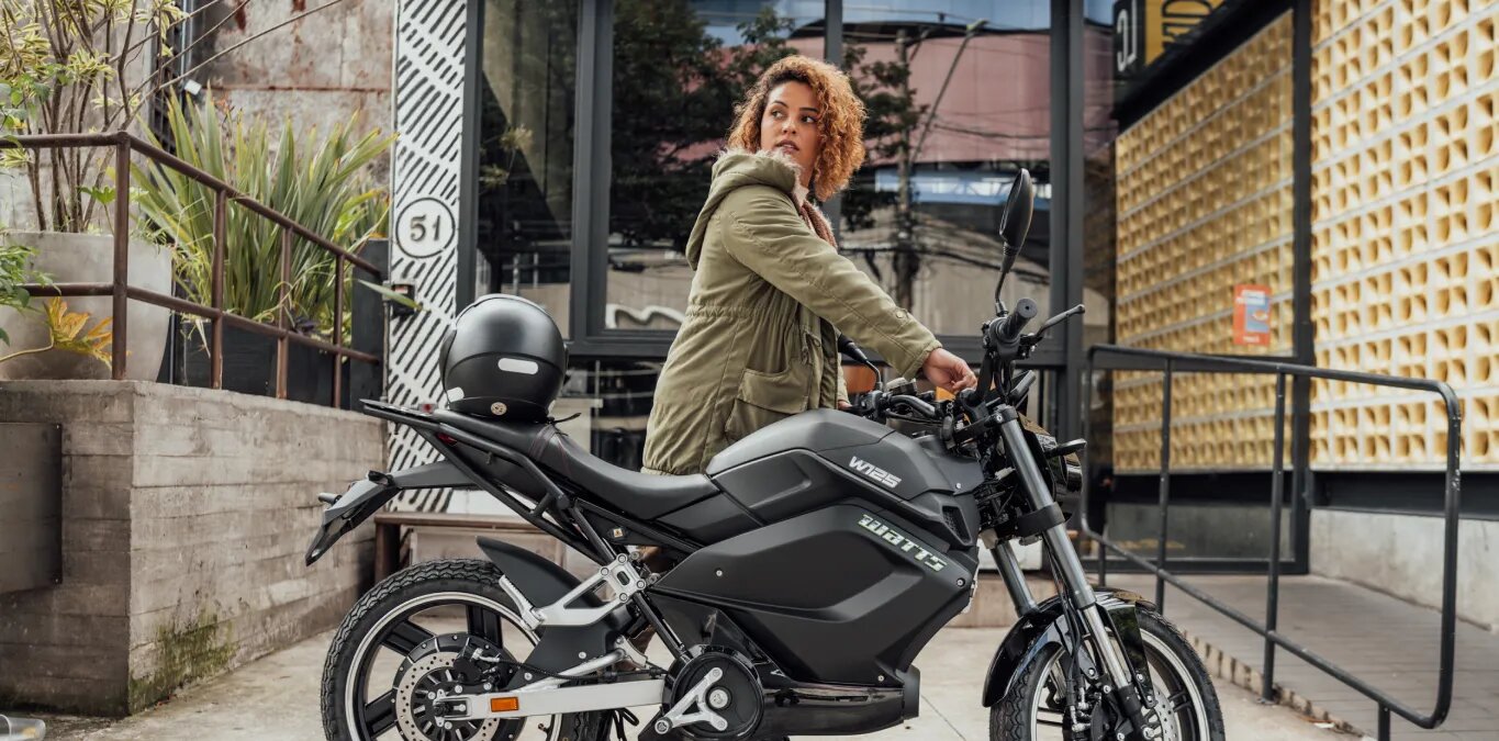 motos elétricas que não precisam de habilitação Mulher ao lado de uma moto elétrica Watts W125