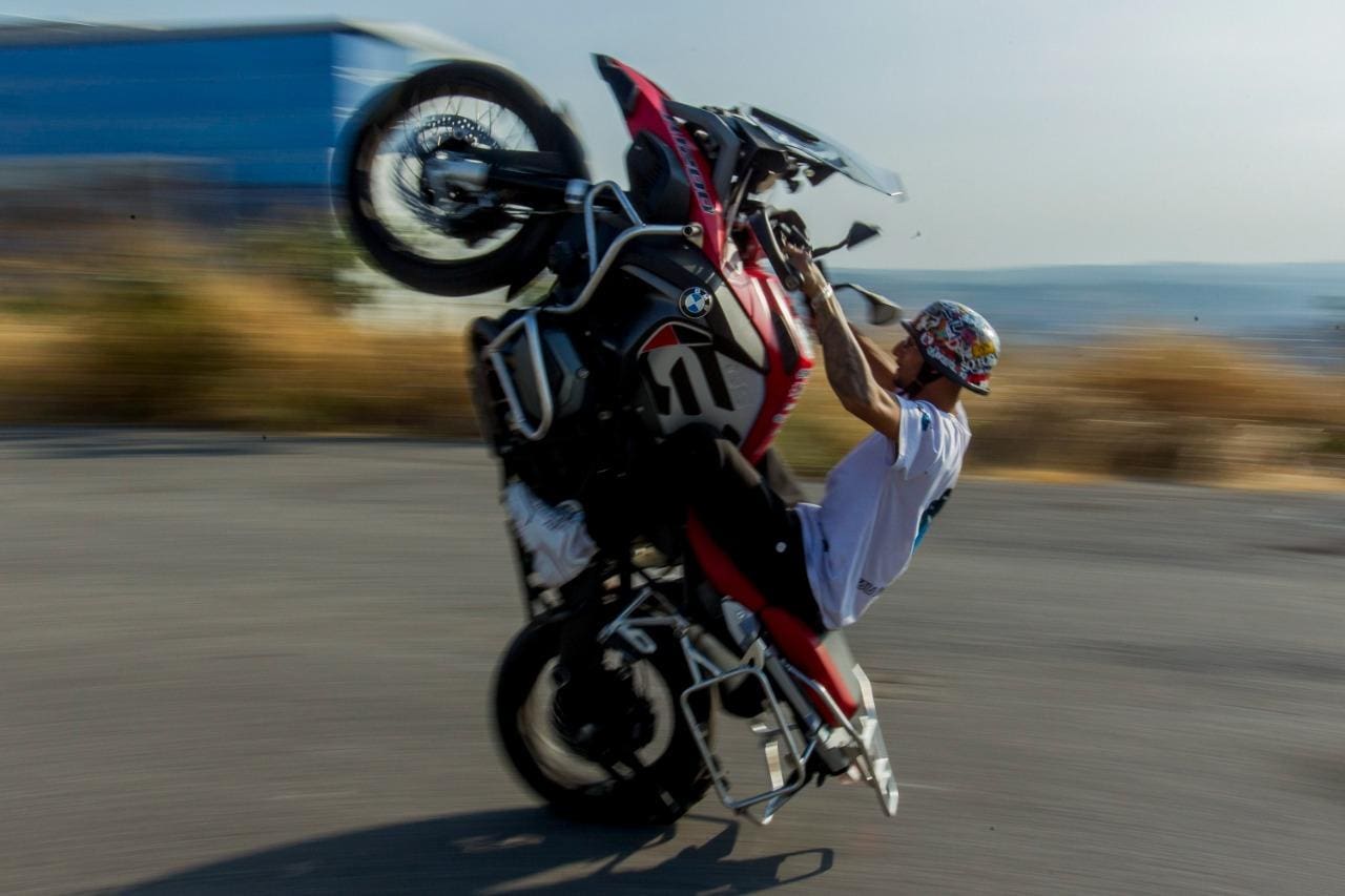 Homem empinando moto na rodovia